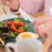 Enjoy a nutritious breakfast with greens, fried egg, and fresh orange juice for a healthy start to your day.