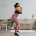 Black woman exercising at home in stylish activewear, promoting a healthy lifestyle.